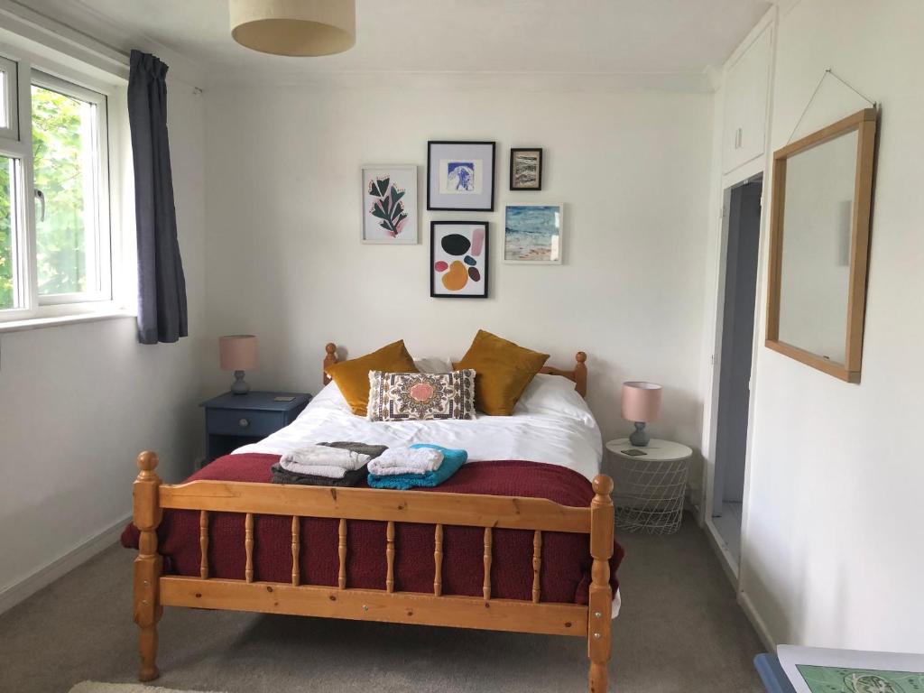 a bedroom with a bed with a wooden frame at Stylish Room Close to Beaches in Falmouth