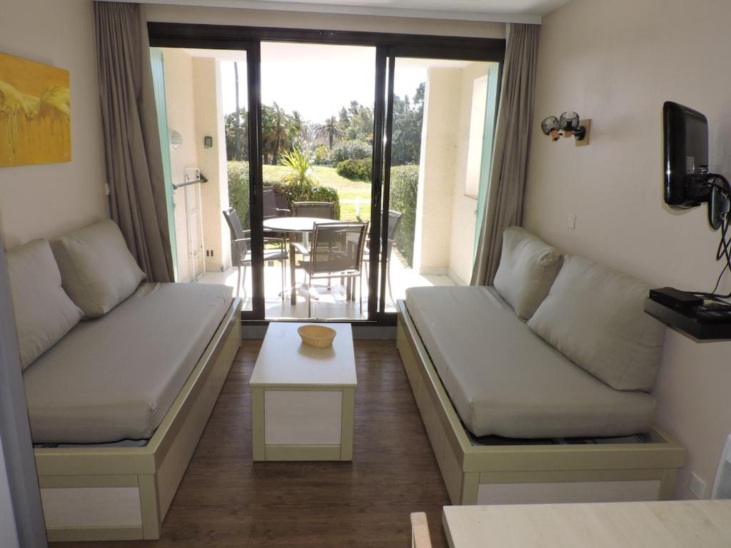 un salon avec deux canapés et une table dans l'établissement Escapade ensoleillée aux Parcs de Grimaud, à Grimaud