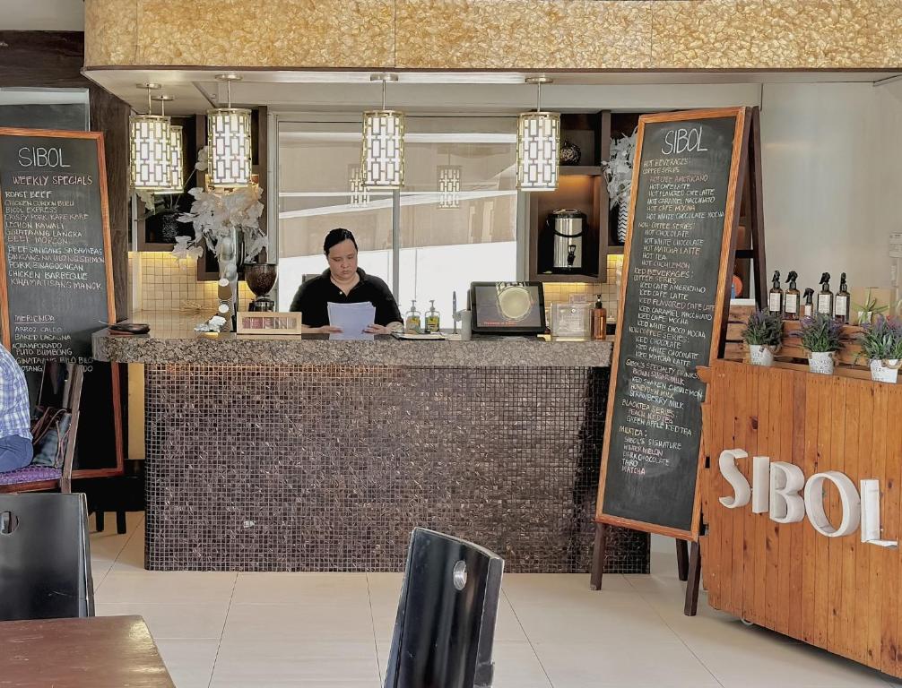 a woman sitting at a counter in a restaurant at The Intramuros Family Suite in Manila