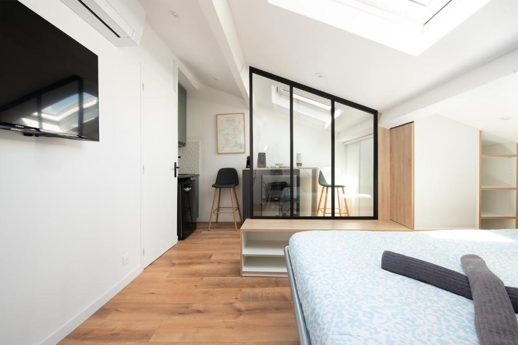 une chambre avec un lit et une grande fenêtre dans l'établissement Ô Saint-Michel - studio climatisé à 200 m du métro, à Toulouse