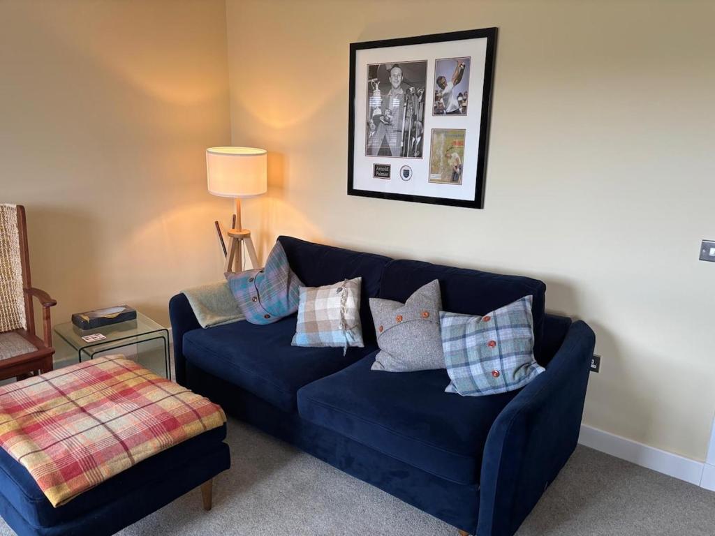 a blue couch with pillows in a living room at Gorgeous Dornoch apartment in Dornoch