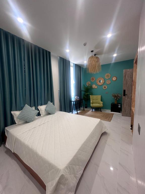 Un dormitorio con una gran cama blanca en una habitación. en Mây Tropic, en Dong Hoi