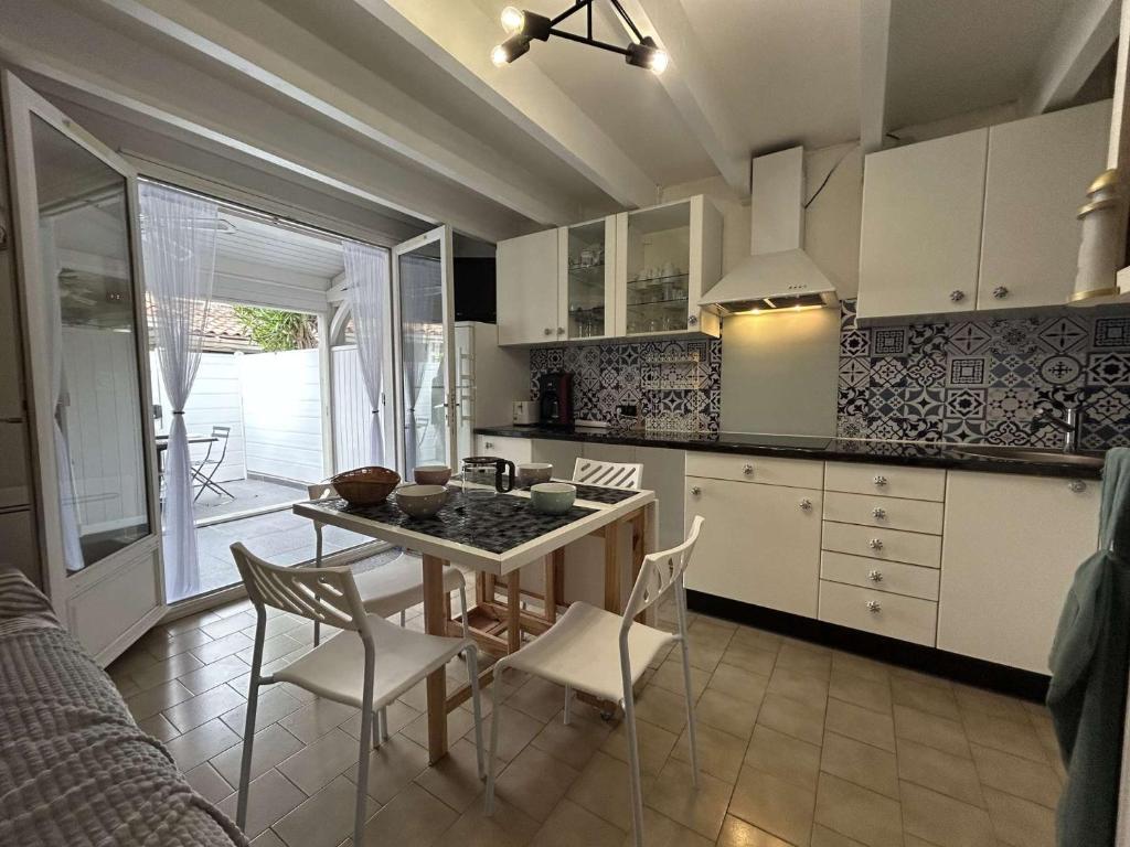 une cuisine avec une table et des chaises dans une pièce dans l'établissement Villa de vacances - type T2 cabine CT720-127, au Cap d'Agde