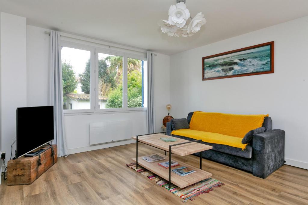 un salon avec un canapé et une télévision dans l'établissement Villa Sandrine Au Calme Jardin, à La Baule