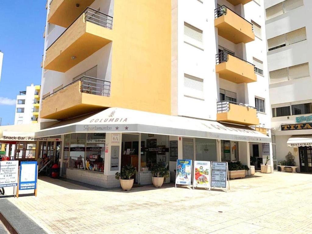 a store in front of a tall building at T1 na 1 linha da Praia da Rocha in Portimão
