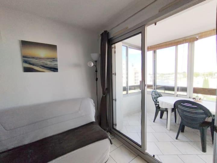 une chambre avec un lit et un balcon avec une table dans l'établissement Reflet du Sud - 4pers - Histoire de cles, au Cap d'Agde