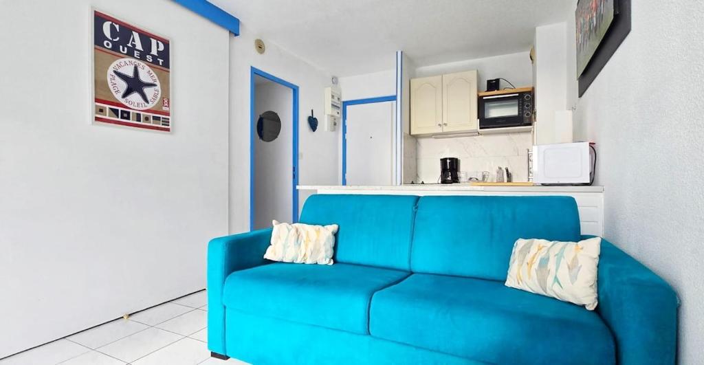 - un canapé bleu dans une chambre avec cuisine dans l'établissement Grande Plage, Quiberon, 2 bedrooms, à Quiberon