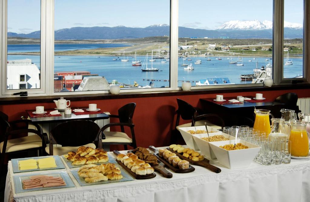 una mesa con comida en ella con vistas a un puerto en MIL810 Ushuaia Hotel en Ushuaia