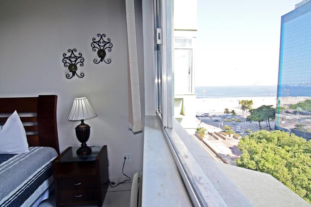 1 dormitorio con vistas al océano desde una ventana en Rio Spot Homes vista mar D027, en Río de Janeiro