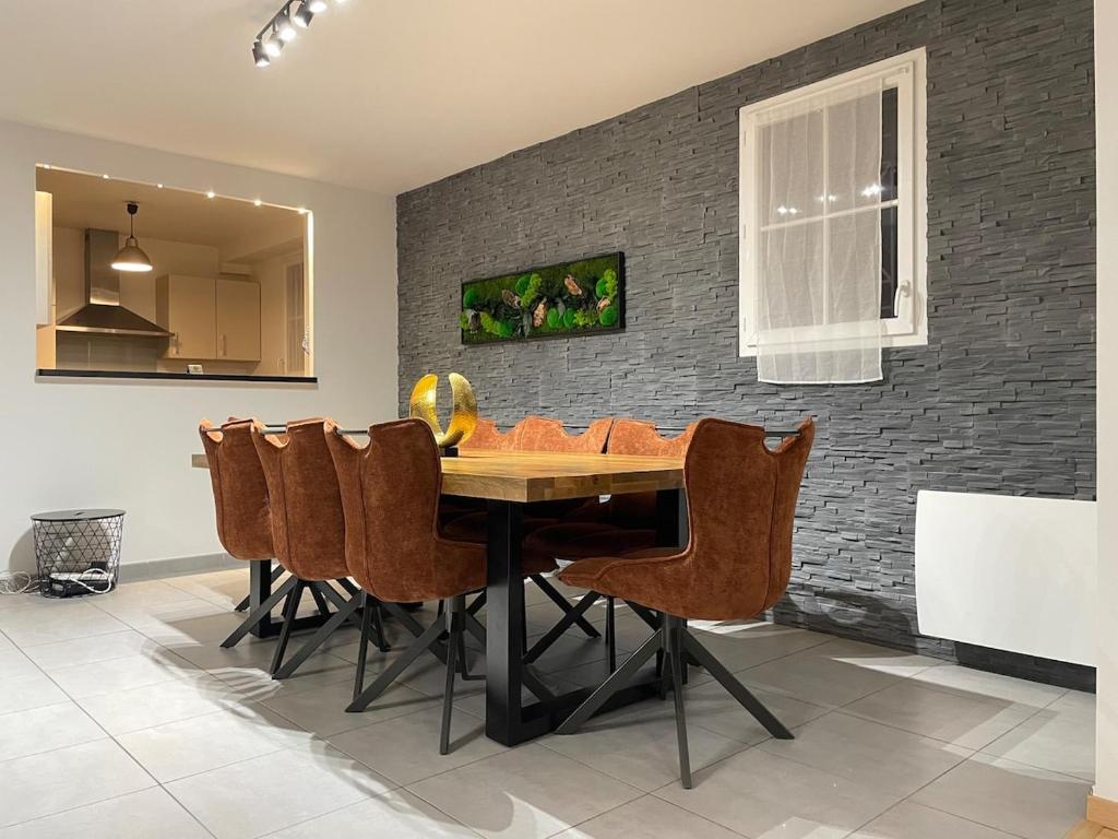 Un comedor con mesa y sillas de madera. en Luxury Villa&6 pers&Parking free, en Magny-le-Hongre