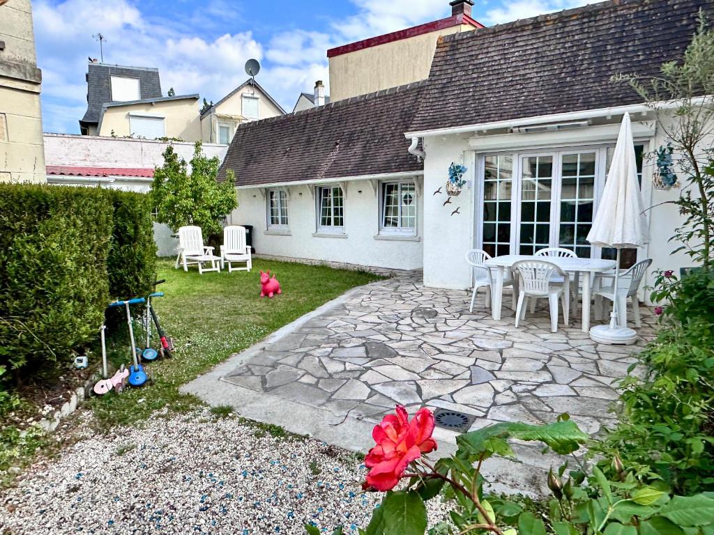 a patio with a table and chairs in a yard at RELAX HOME Maison et studio ensemble in Deauville