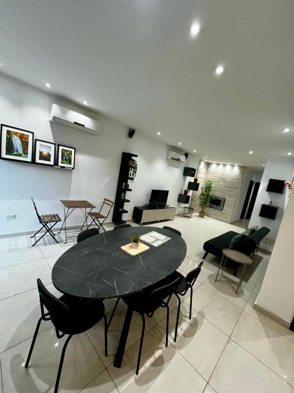 a living room with a black table and chairs at Stardust in San Ġwann