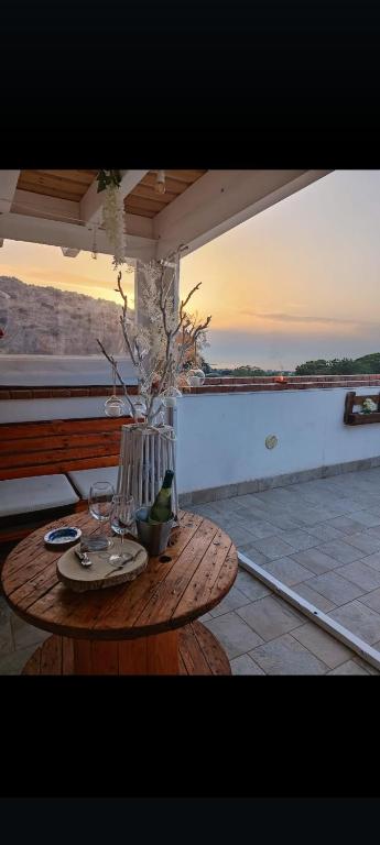 a wooden table with a vase on a patio at il tramonto in Capaci