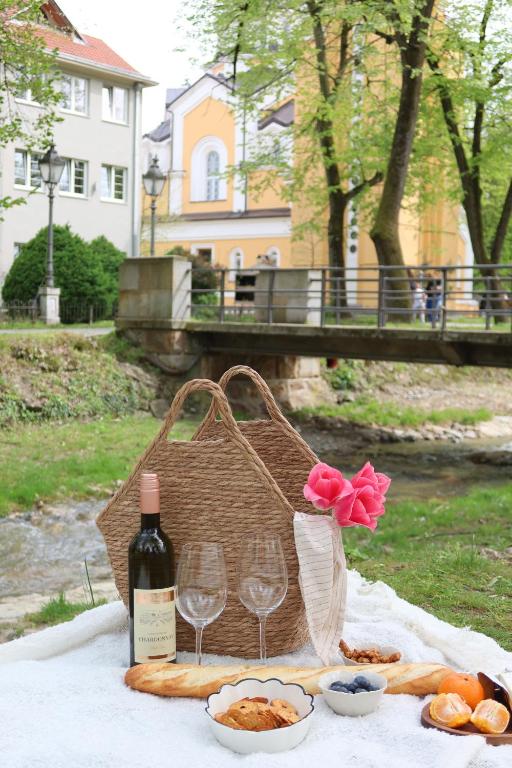 a picnic table with wine glasses and a basket of food at Banja Maison in Vrnjačka Banja