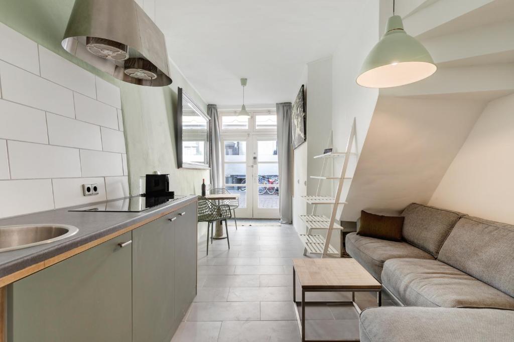 Una cocina y una sala de estar con un sofá. en Beautiful 'tiny house' in Utrecht City Center, en Utrecht