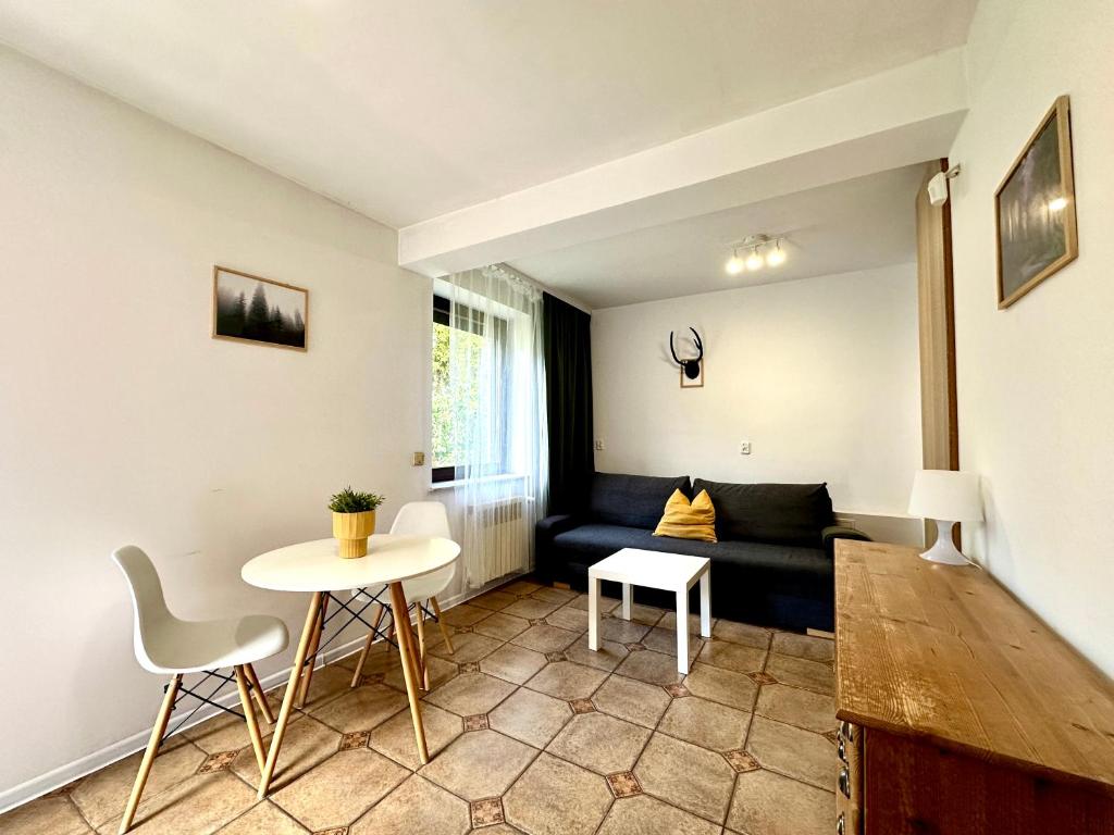 ein Wohnzimmer mit Sofa und Tisch in der Unterkunft Studio Żubrowe II in Przymorze