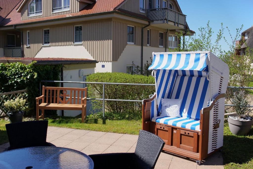 Una gran silla de playa con una raya azul y blanca. en Birkenhof App 64, en Wustrow