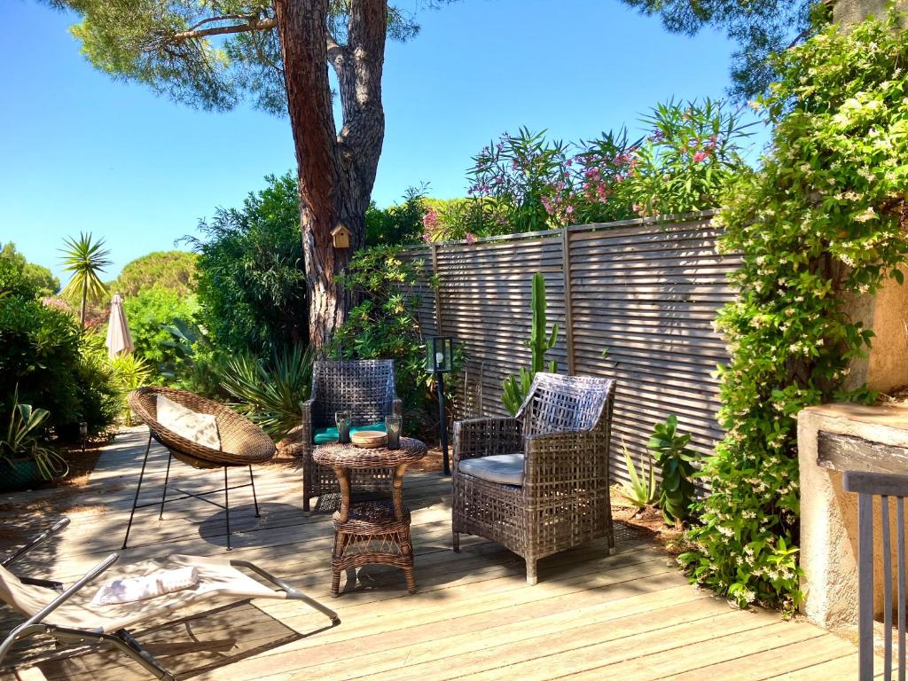un groupe de chaises et de tables sur une terrasse en bois dans l'établissement GIGARO - Terrasses et jardin à 5mn à pied de la plage - piscine & parking, à La Croix-Valmer