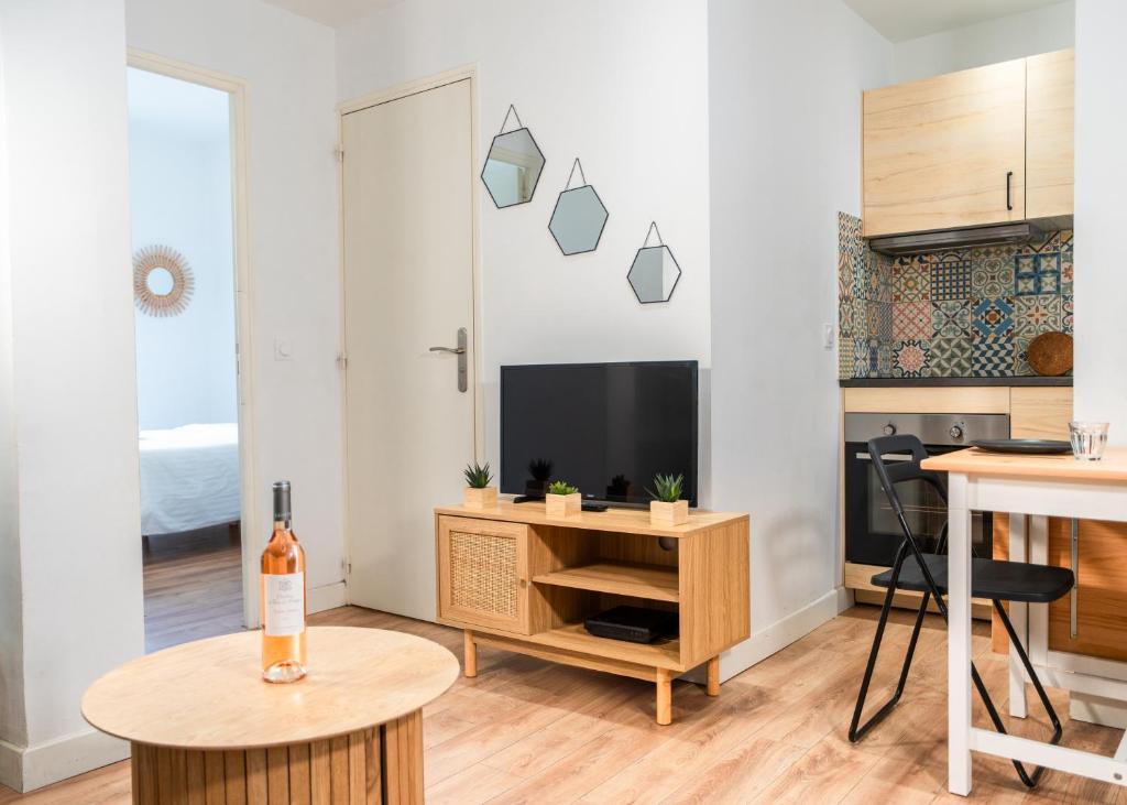 a living room with a tv and a table at Le Refuge Urbain - Port à 2 pas & animaux acceptés in Toulon