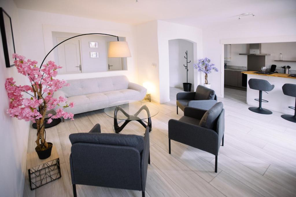 un salon avec un canapé blanc et des chaises dans l'établissement Grand appartement 3 chambres - Centre Toulon, à Toulon