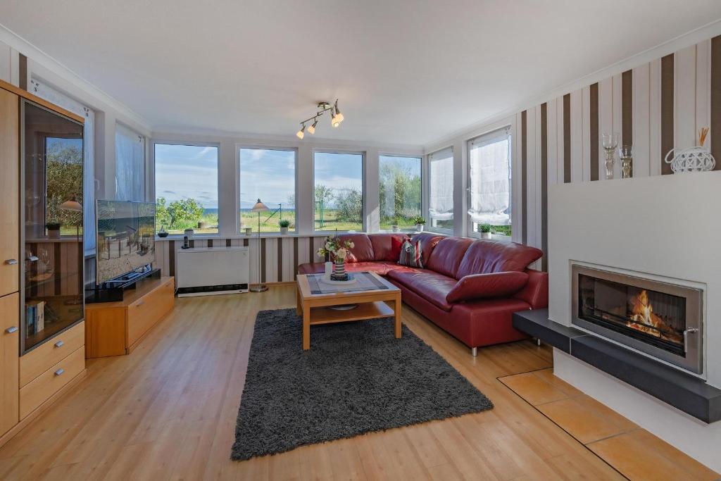 Una sala de estar con un sofá rojo y una chimenea. en Strandhaus Möwe, en Zempin