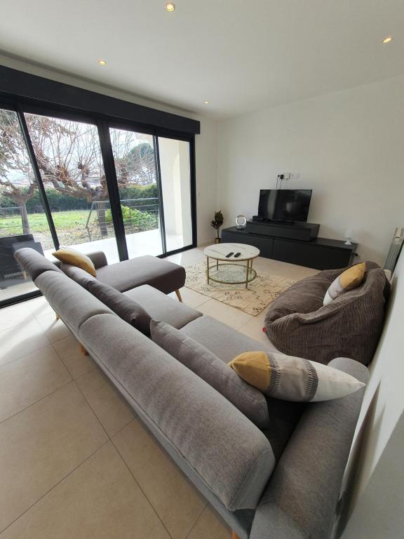 - un grand canapé dans le salon avec un piano dans l'établissement Villa Saint Michel, à Saint-Félix-de-Lodez