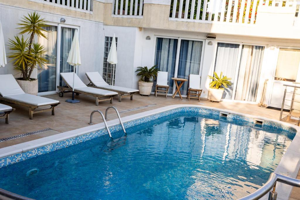een zwembad in een hotel met stoelen en een terras bij Apartman Tekoma Herceg Novi in Herceg-Novi