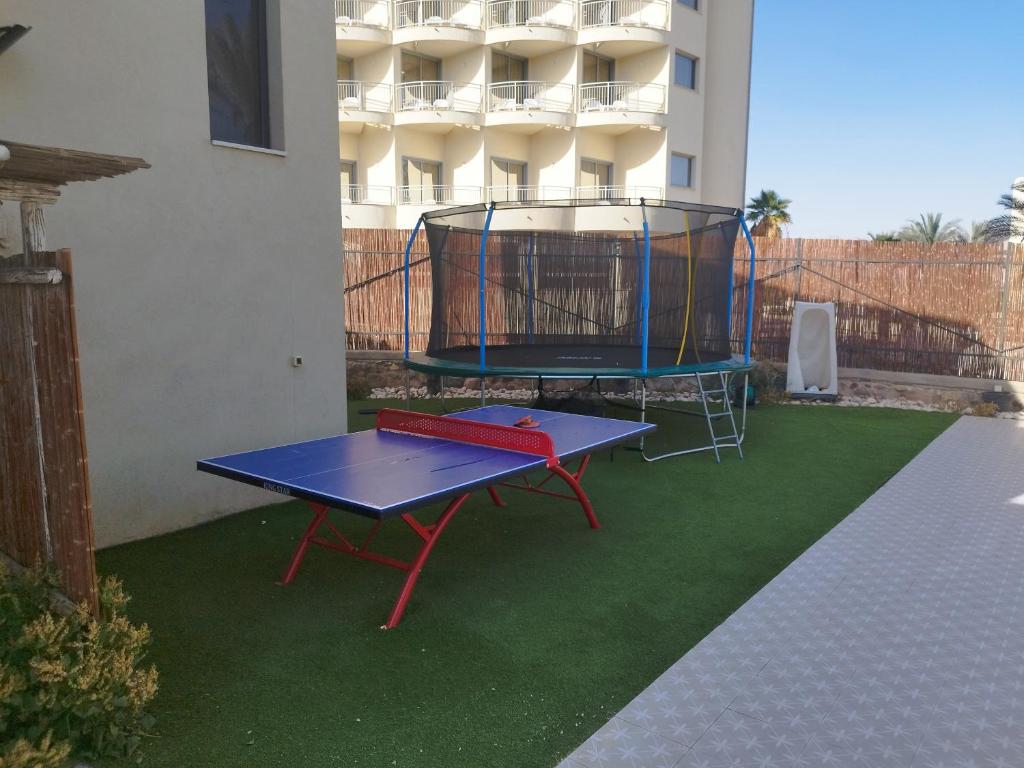a blue ping pong table with a cage on the grass at YalaRent Cliff side villa with private pool in Eilat