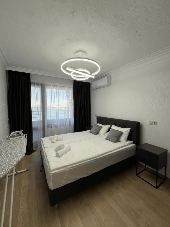 ein Schlafzimmer mit einem großen weißen Bett und einem Kronleuchter in der Unterkunft Lago Mare Apartment in Pomorie