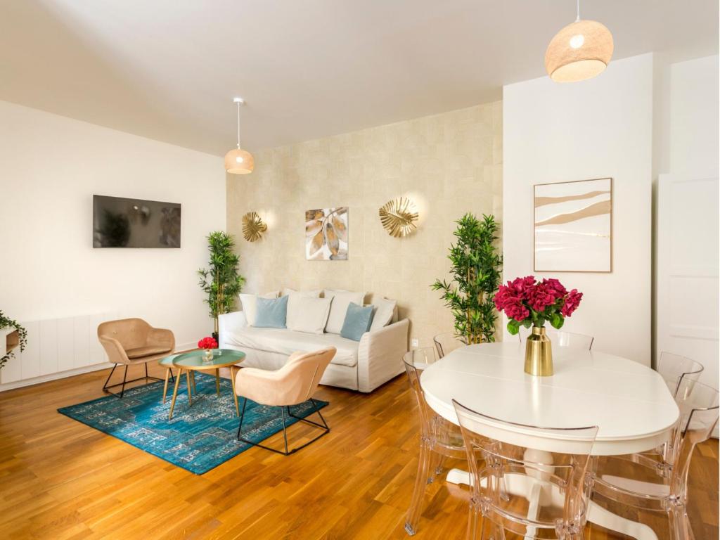 un salon avec un canapé blanc et une table dans l'établissement Merveil - Family Suite - Champs Elysees - Monceau, à Paris