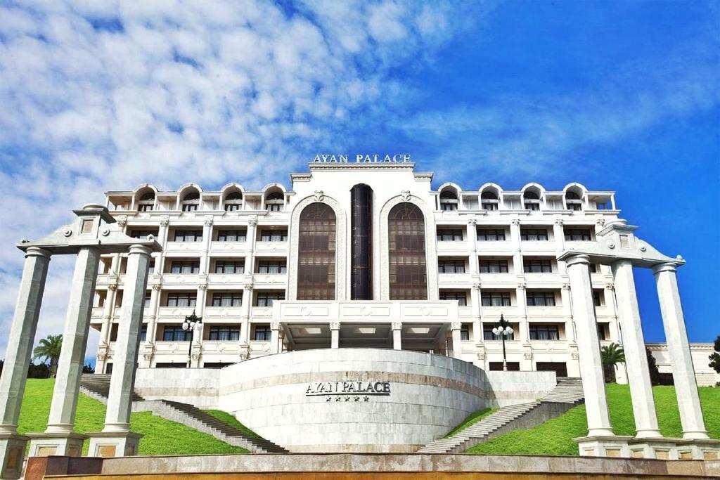 a large white building with steps in front of it at Ayan Palace Hotel in Tovuz