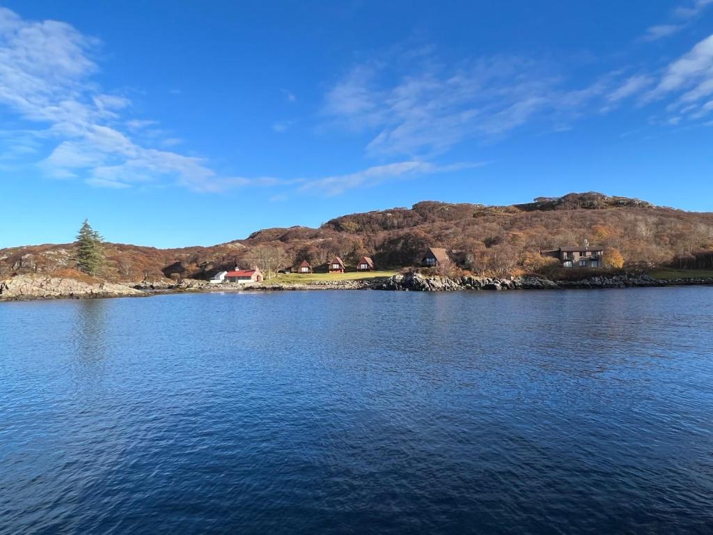 ein großer Wasserkörper mit Häusern auf einem Hügel in der Unterkunft Lochinver Holiday Lodges & Cottages in Lochinver