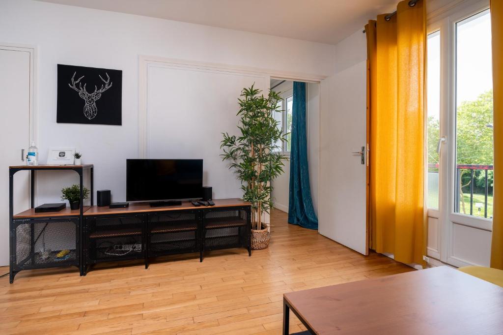 un salon avec une télévision à écran plat sur une table dans l'établissement Appartement 3 ch Wifi - Breizh Key, à Lorient