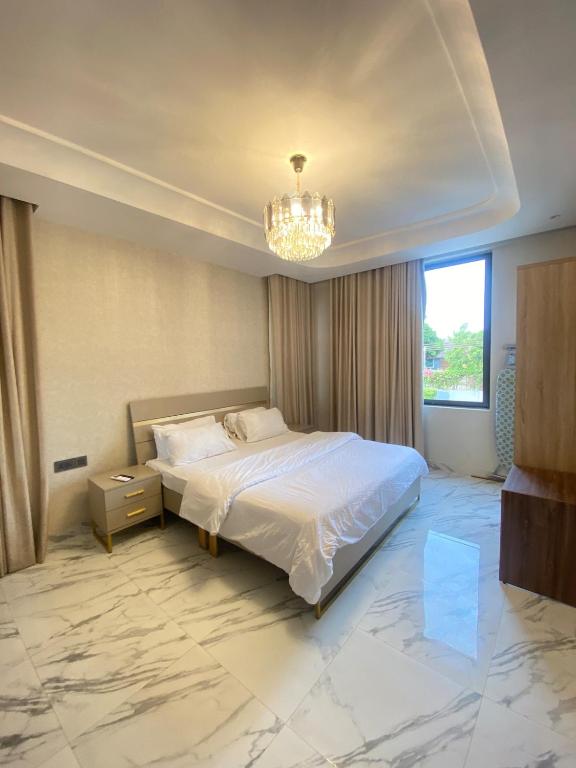 a bedroom with a large bed and a chandelier at Executive One bed - East legon in Accra