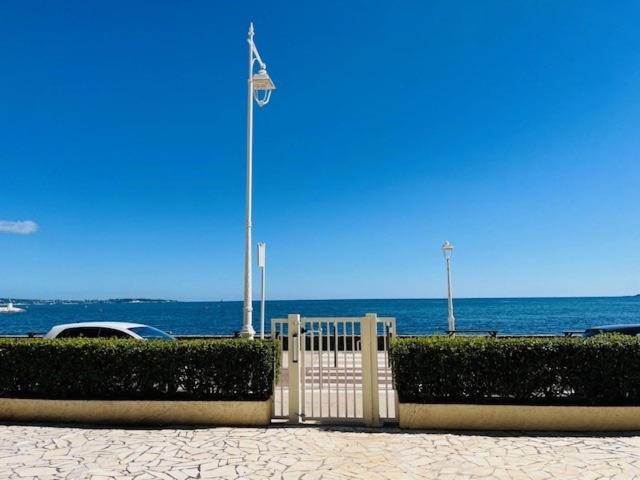a white fence with a flag on the beach at Cannes Palm Beach - Brand New Studio - Oasis of Calm in Cannes