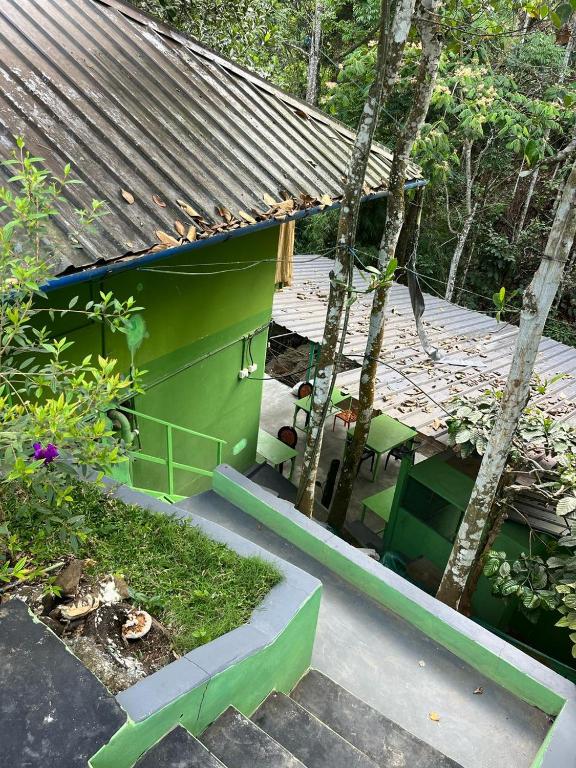 a small green house with a table and chairs at Bamboo leaf Homestay in Meppādi