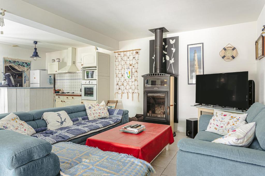 - un salon avec deux canapés bleus et une cheminée dans l'établissement Séjour agréable entre forêt et mer, à Dolus-d'Oléron