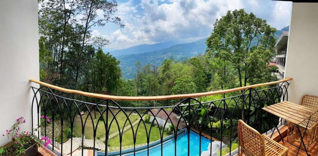 a balcony with a view of a pool and mountains at VITS Kunjham Retreat in Gangtok