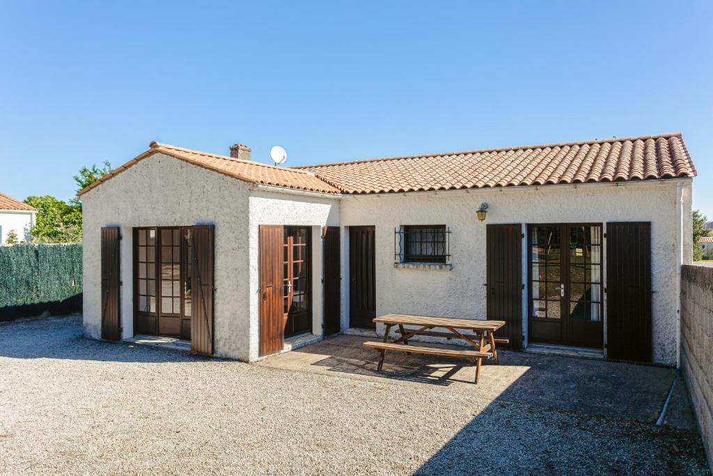 une maison avec une table de pique-nique devant elle dans l'établissement Maison au Coeur de Grand Village, à Grand-Village-Plage