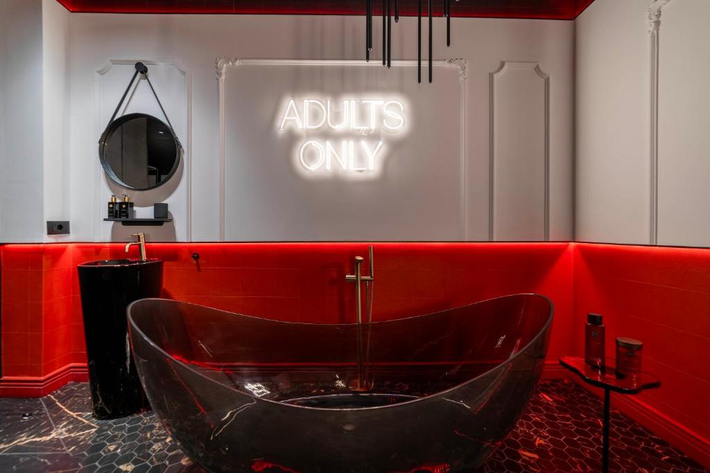 La salle de bains est pourvue d'une baignoire dans un mur rouge. dans l'établissement L'Amour Suite - romantic getaway, à Tivat