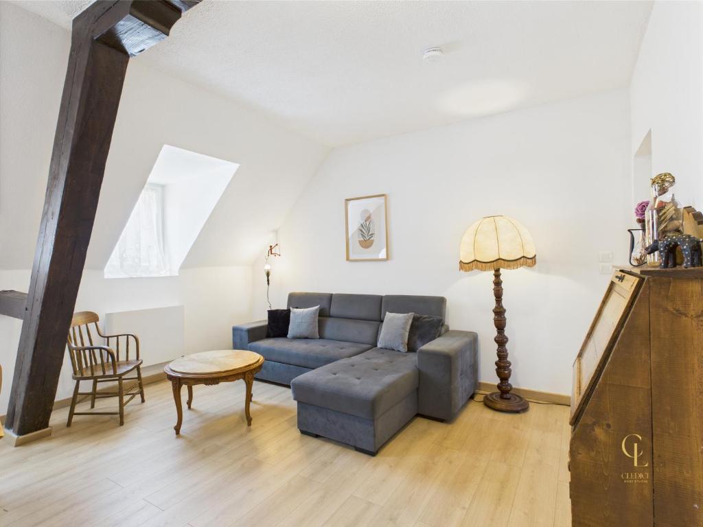 un salon avec un canapé bleu et une table dans l'établissement Cocon Jaune - Duplex 2e étage prox centre Mulhouse, à Mulhouse