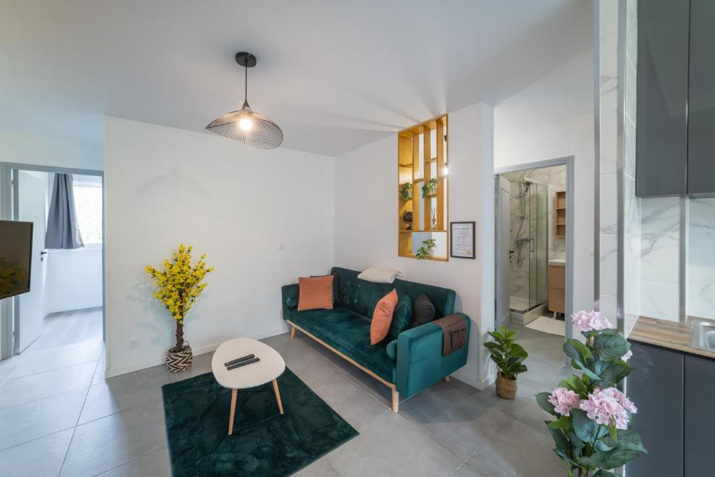 a living room with a green couch and a table at Spacieux Appartement 4 Chambres in Hérouville-Saint-Clair