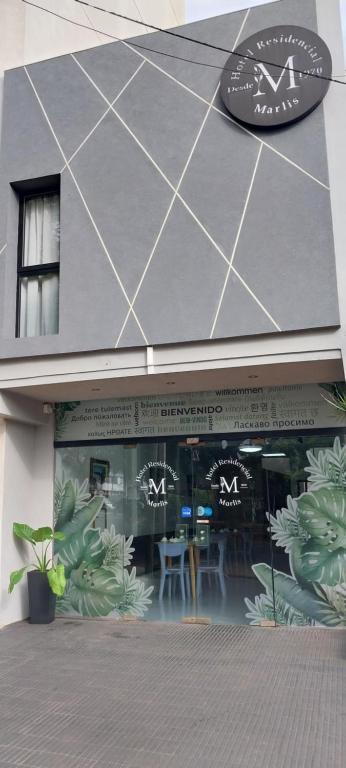una tienda con un cartel en el costado de un edificio en Hotel Residencial Marlis, en Posadas