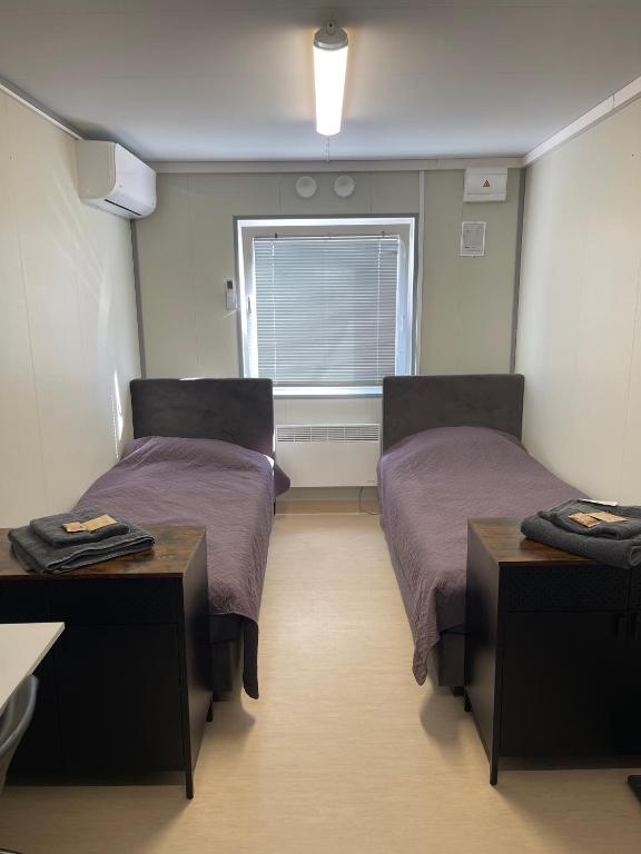 a room with two beds and a window at ModulHaus Pabradeje Trumpalaike Nakvyne in Pabradė