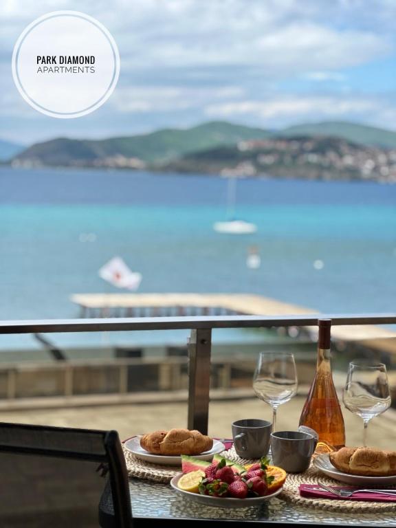 a table with plates of food and wine glasses at Park Diamond Apartments in Ohrid