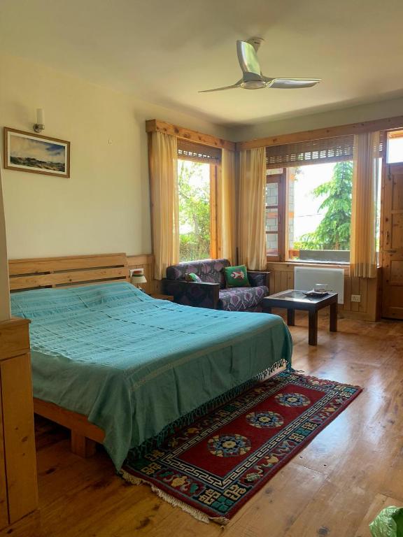 a bedroom with a bed and a ceiling fan at The Green Mountain Lodge in Jāmb