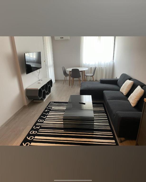 a living room with a black couch and a table at Апартамент 402 in Sliven