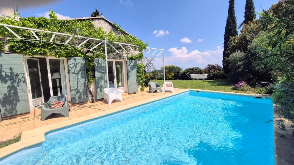une piscine devant une maison dans l'établissement Villa Notre-Dame avec piscine, à Rochefort-du-Gard