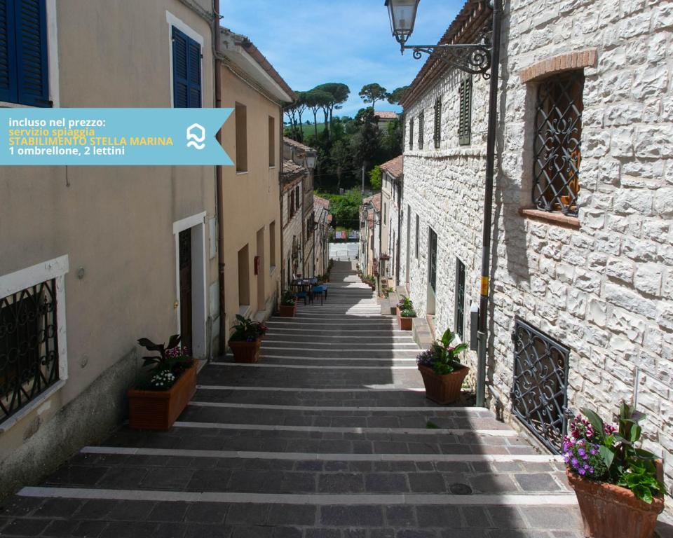 eine Gasse mit Steingebäuden und Topfpflanzen in der Unterkunft Numana, delizioso cielo-terra a 150mt dal mare - N099 in Numana