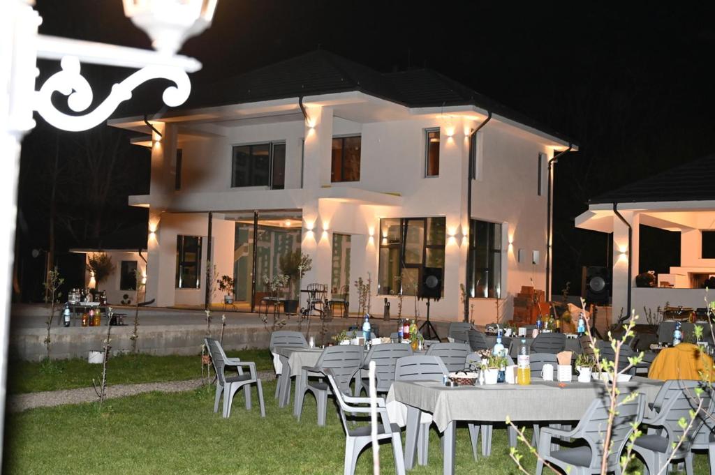 a group of tables and chairs in front of a house at Casa Movilita El DoD in Moviliţa